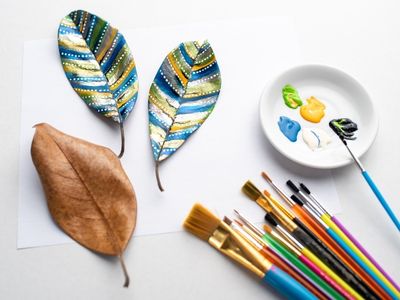 Paintbrushes and leaves painted with line and dots.