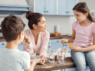 Happy mother and two children conversing in kitchen